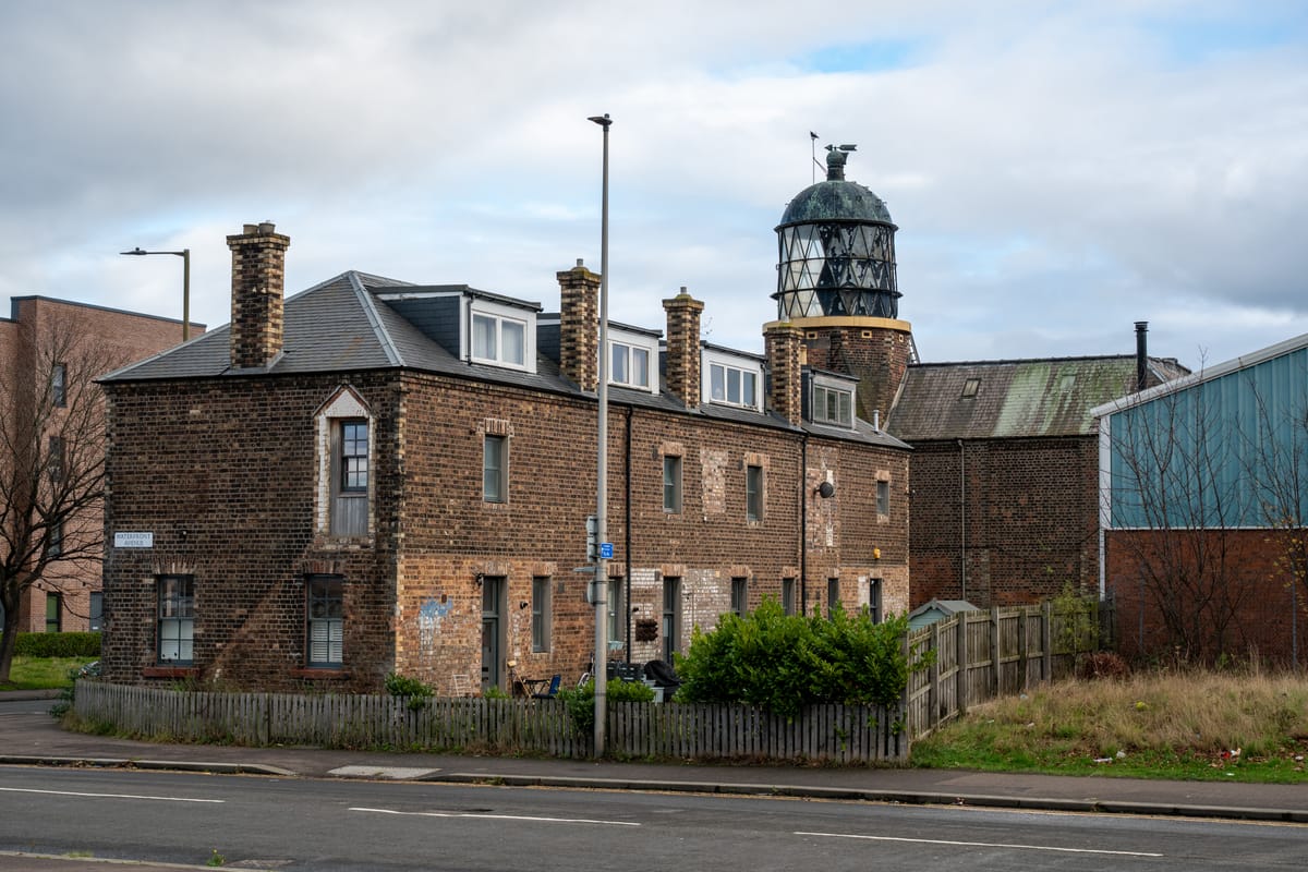 A brick building with a glass lighthouse on top.