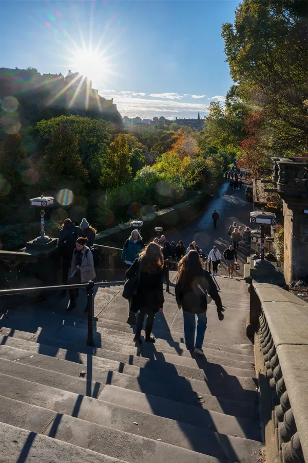 People on stairs in a city park with a castle on the horizon.