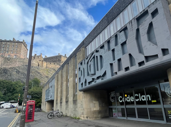 A building in the shadow of a castle. 