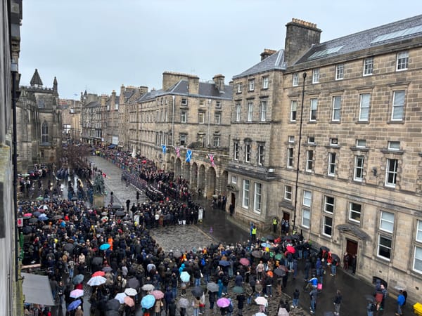 A large group of people standing together in a city street.